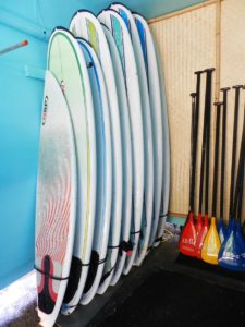 Lots of surfboards leaning against wall